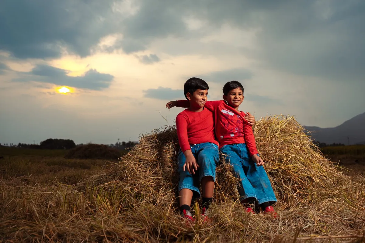 Two children sitting together in a field