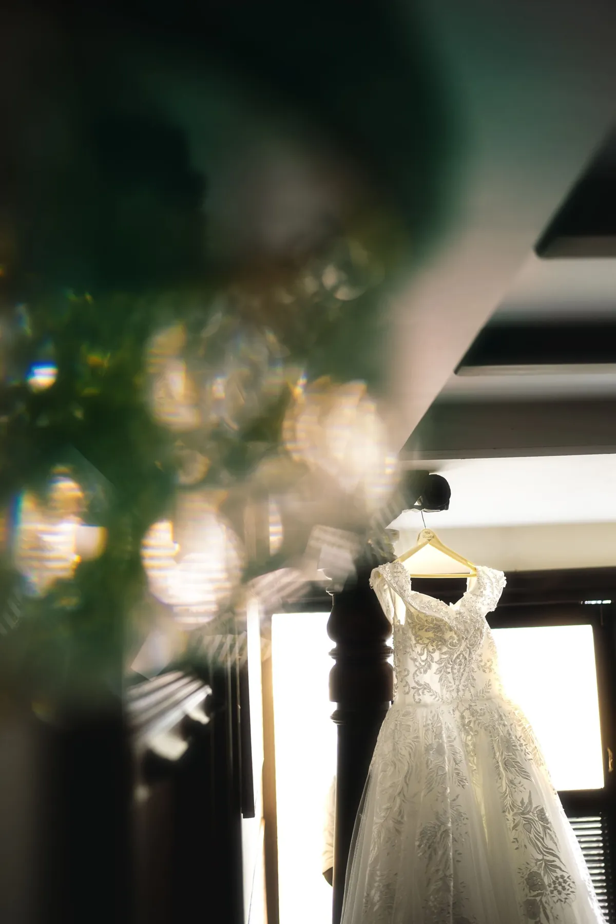 Wedding gown hanging in soft window light