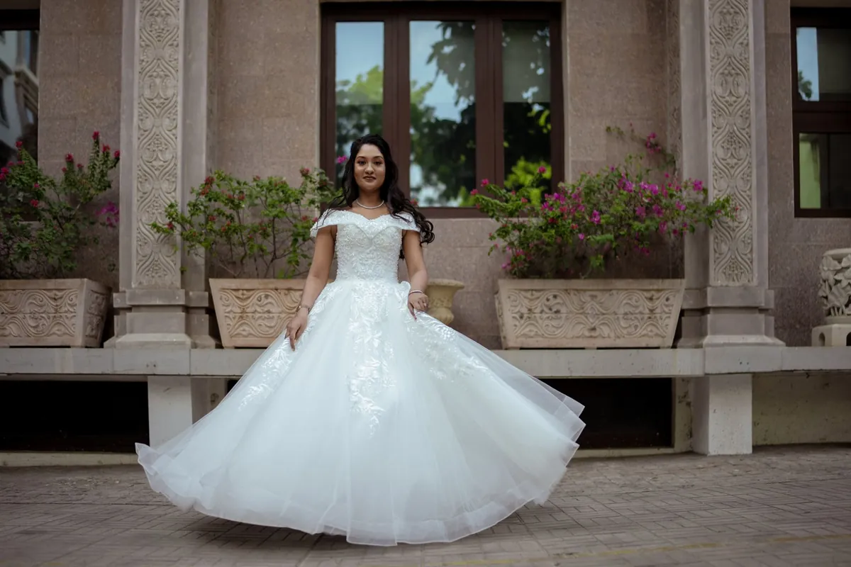 Bride in a white gown framed by stone architecture